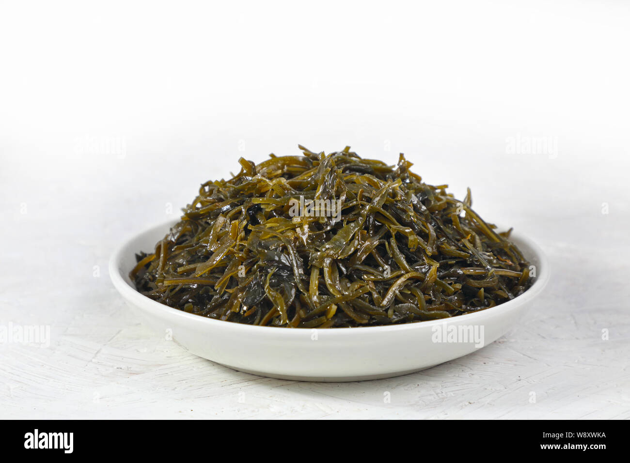 Insalata di alghe è un prodotto alimentare ricco di iodio. su sfondo bianco. Foto Stock