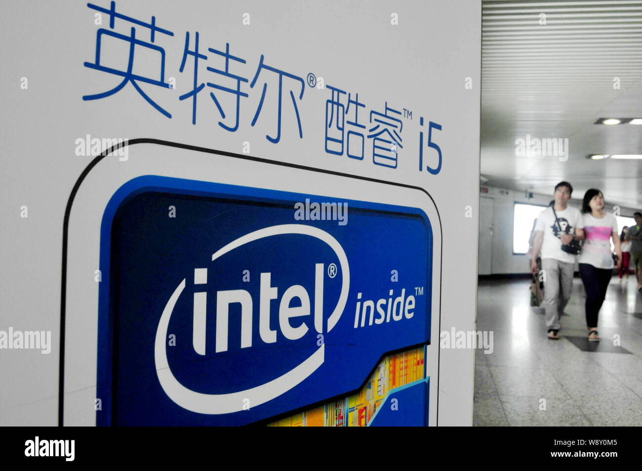 --FILE--pedoni a piedi passato un annuncio pubblicitario per la tecnologia di processore Intel Core i5 a una stazione della metropolitana a Shanghai in Cina, il 25 maggio 2013. Intel Corp., lottando per brea Foto Stock