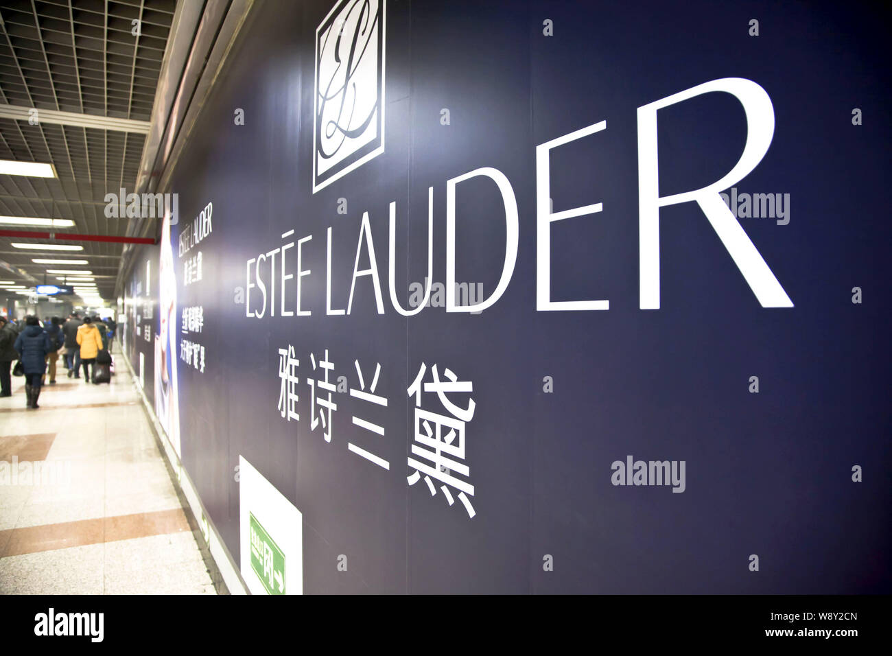 --FILE--i passeggeri a piedi passato un annuncio pubblicitario per la Estee Lauder ad una stazione della metropolitana di Pechino, Cina, 12 gennaio 2013. Moda di lusso burbe di etichetta Foto Stock