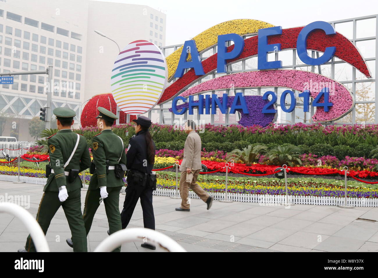 Poliziotti cinesi patrol passato un APEC-tema parterre su una strada a Pechino in Cina, 31 ottobre 2014. In Cina il martedì (4 novembre 2014) premuto il suo Foto Stock