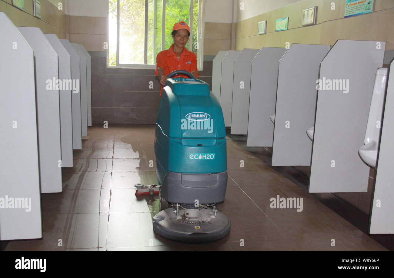--FILE--un lavoratore di pulizia lucida il pavimento in un bagno pubblico di Yichun city east Chinas provincia di Jiangxi, 25 settembre 2012. Fino al 75 per cento Foto Stock