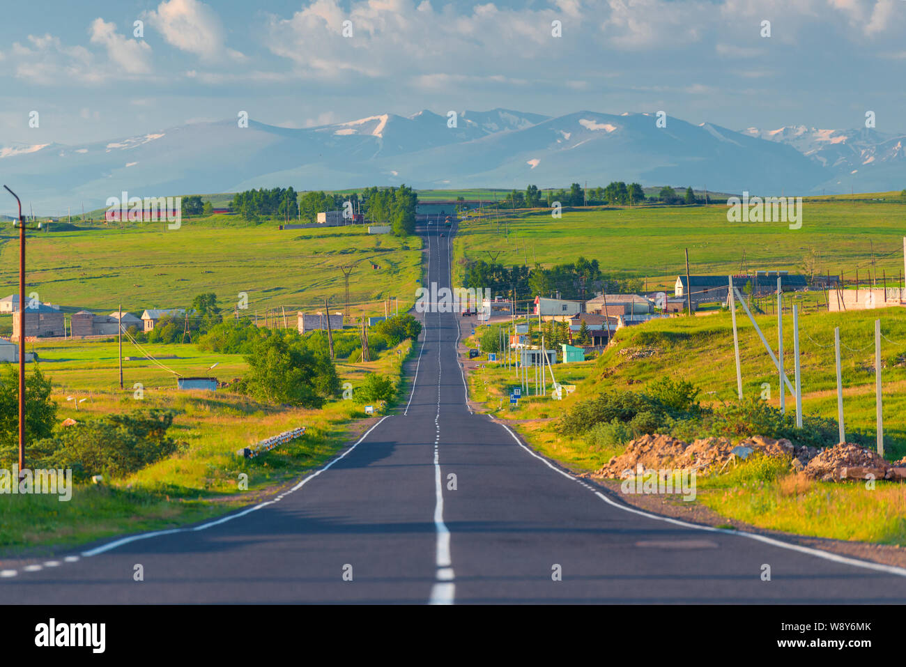Rotta diretta verso le montagne attraverso il villaggio in Armenia al mattino Foto Stock