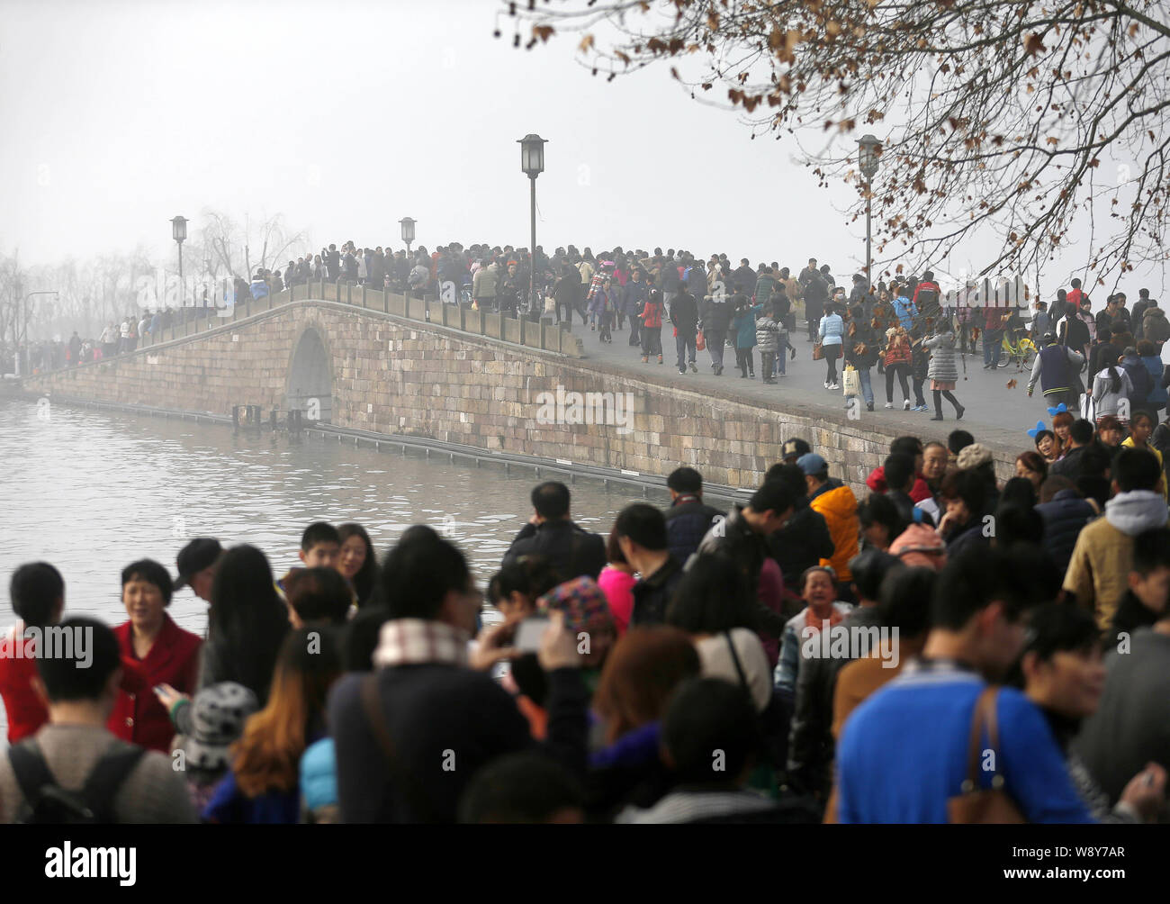 I turisti affollano la passeggiata lungo la riva del Lago Ovest durante il nuovo anno lunare cinese vacanza o Festival di Primavera in Hangzhou, Oriente Cina Foto Stock