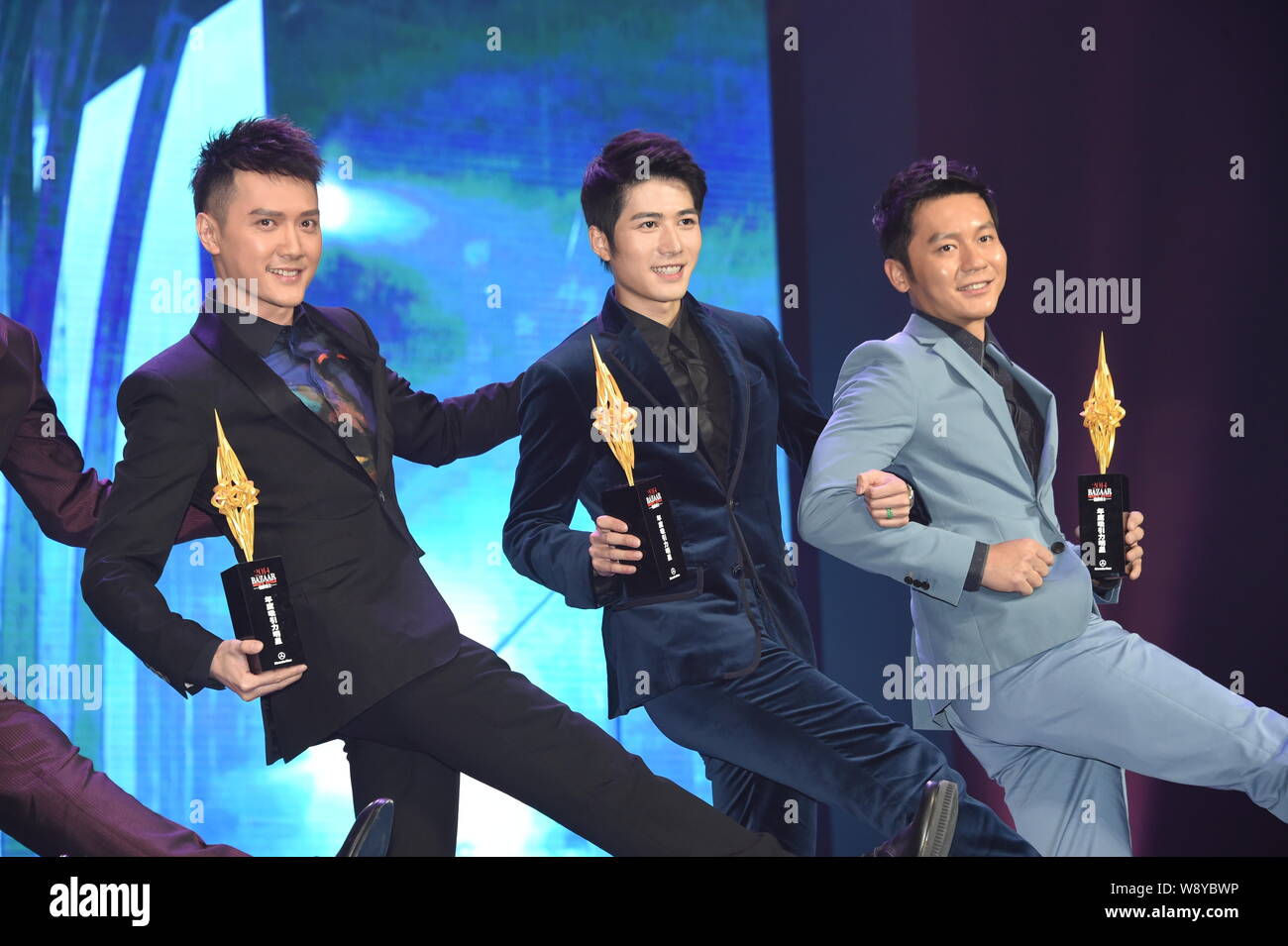 (Da sinistra) attori cinesi Feng Shaofeng, Chen Xuedong e Li Chen ballare durante la cerimonia di premiazione per il popolo del Bazaar Award 2014 a Pechino Foto Stock