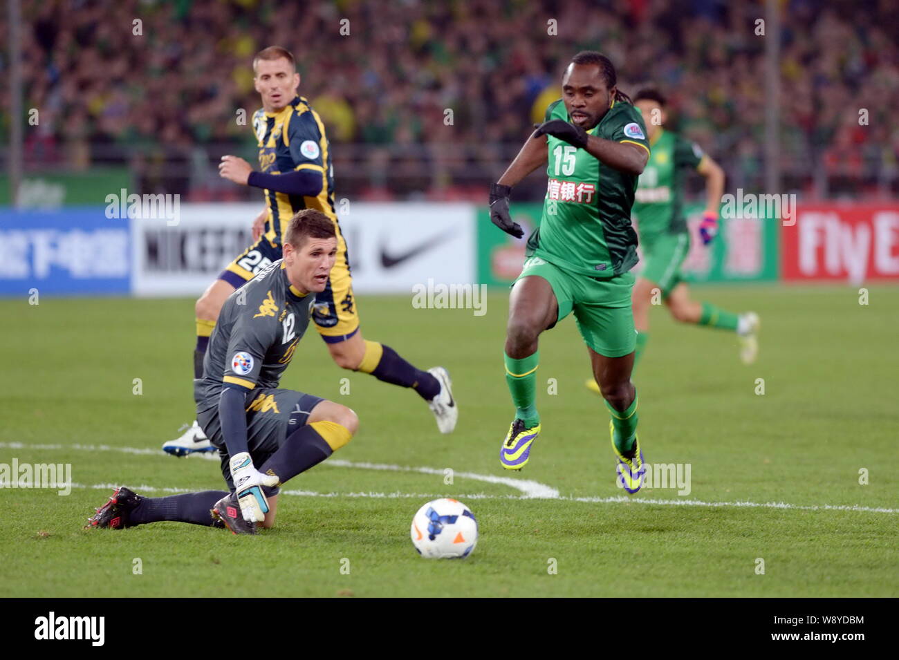 Maduabuchi Peter Utaka di porcellane Guoan Pechino, destra dribbling passato portiere Liam Rhys Reddy di Australias Central Coast Mariners durante il loro Grou Foto Stock