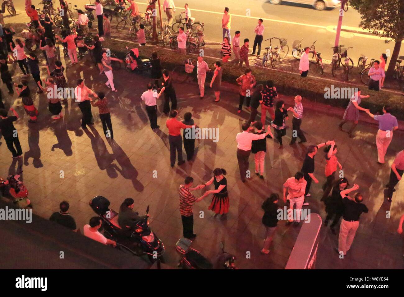 Un gruppo di residenti locali dance in un pubblico spazio aperto vicino al n. 3 ingresso della citata lamellatura Road stazione della metropolitana linea 8 in Cina a Shanghai, 4 giugno 2014 Foto Stock
