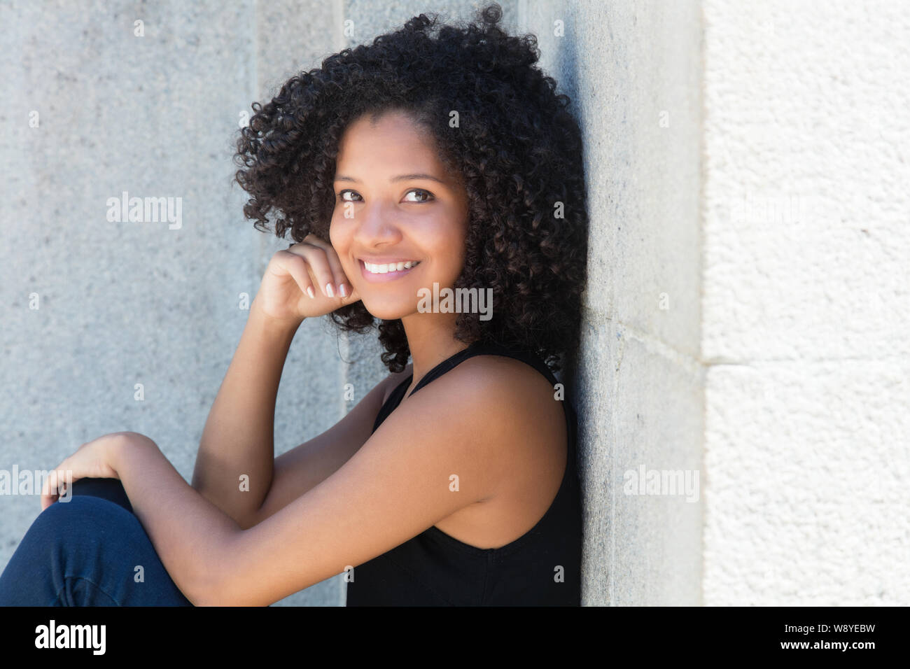 Giovane africano donna americana con ricci capelli neri all'aperto in estate Foto Stock