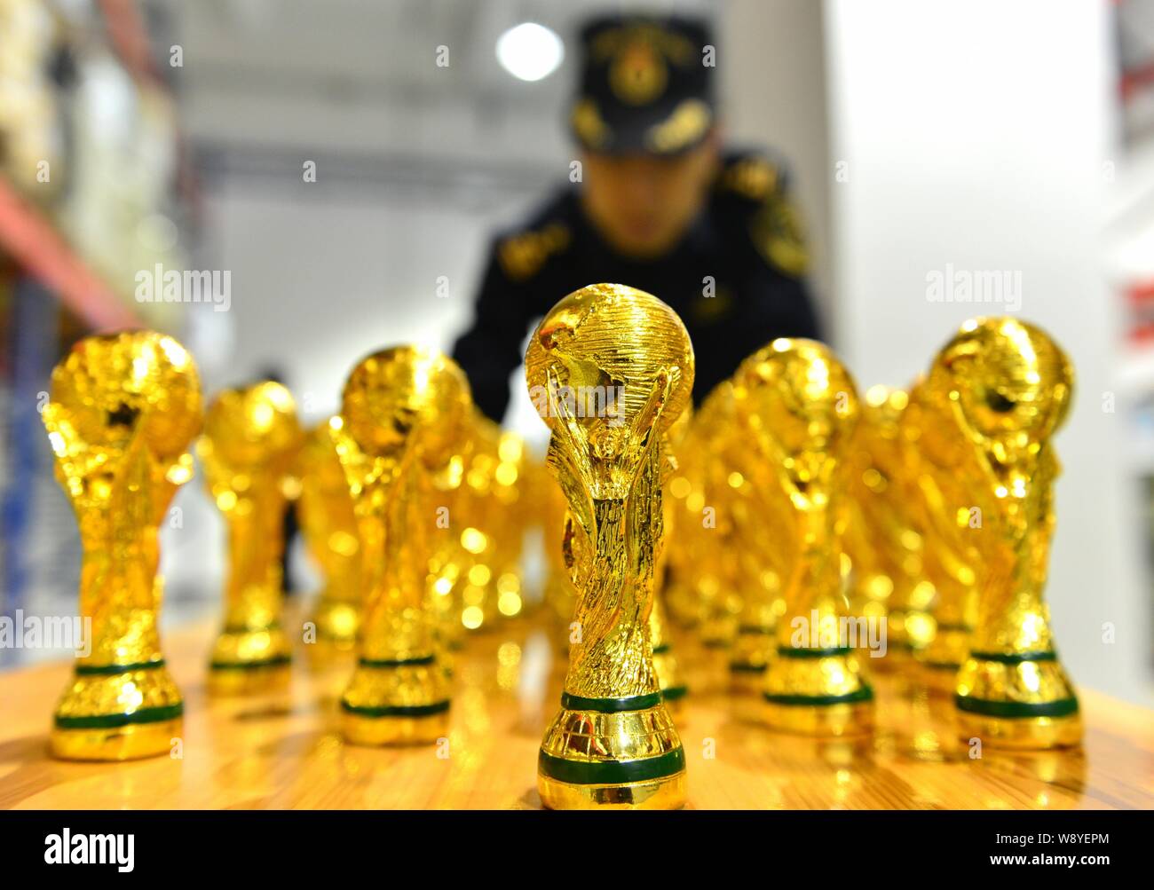 Un Cinese funzionario doganale verifica sequestrati fake World Cup trofei in corrispondenza di un magazzino in Yiwu City East Chinas nella provincia di Zhejiang, 24 aprile 2014. 18,860 fa Foto Stock