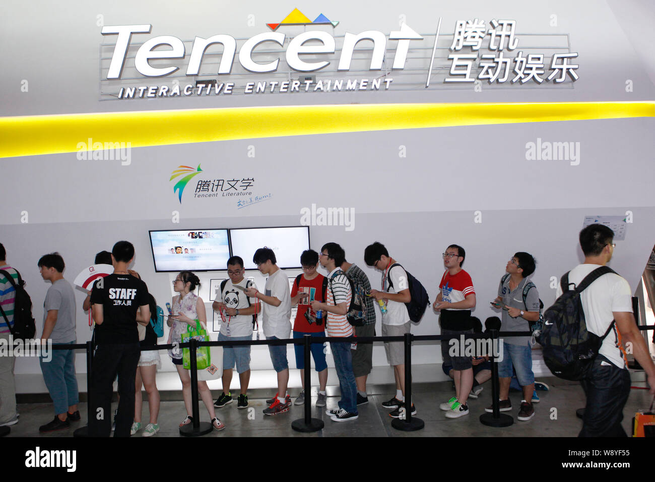 --FILE--i visitatori in coda fino a fronte della gabbia di Tencent Interactive Entertainment durante una mostra a Shanghai in Cina, 3 agosto 2014. Tencen Foto Stock