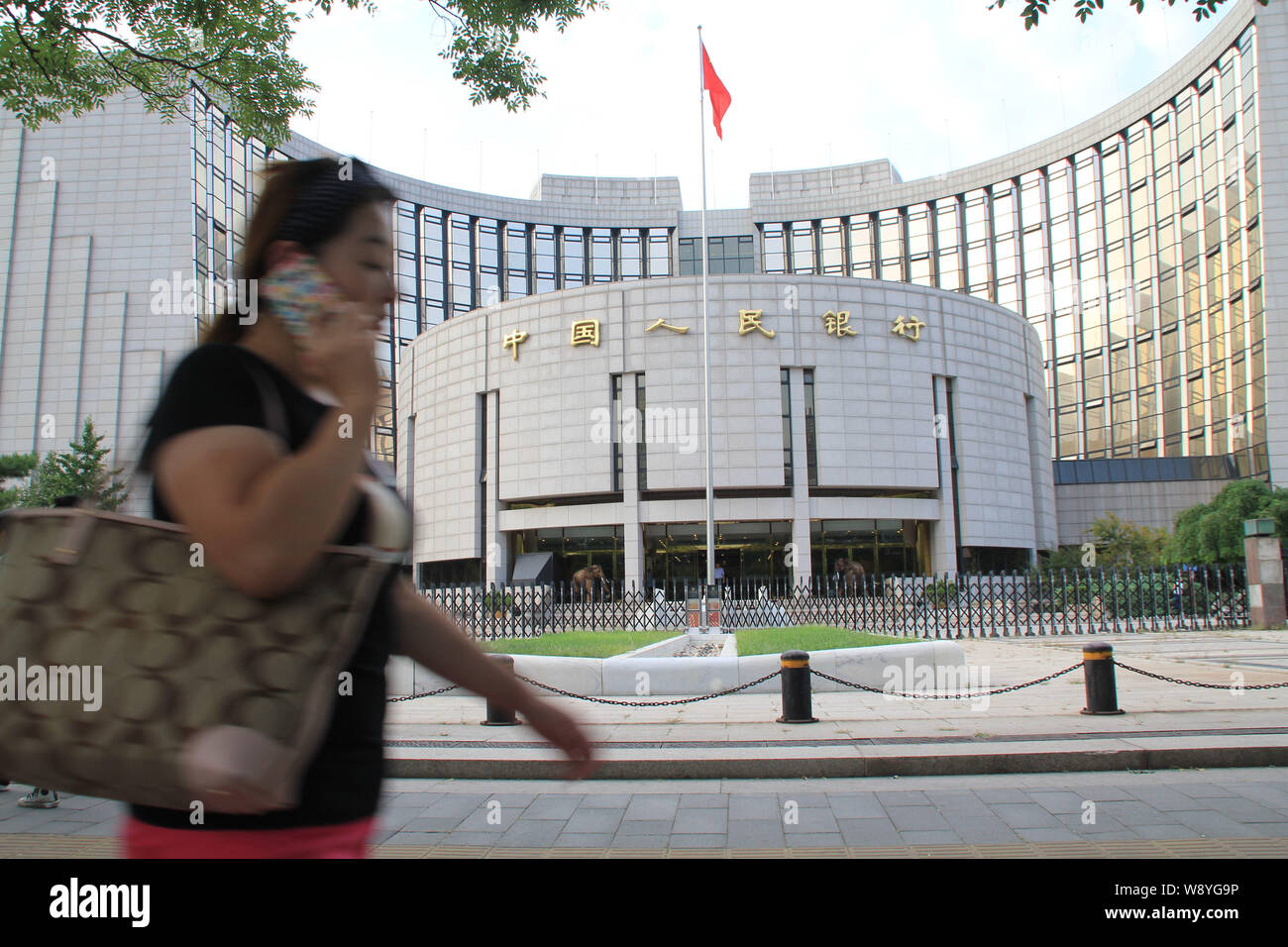 --FILE--un pedone colloqui sul suo telefono cellulare come lei cammina in passato la sede e sede della Banca Popolare di Cina (PBOC), la Cina la centra Foto Stock