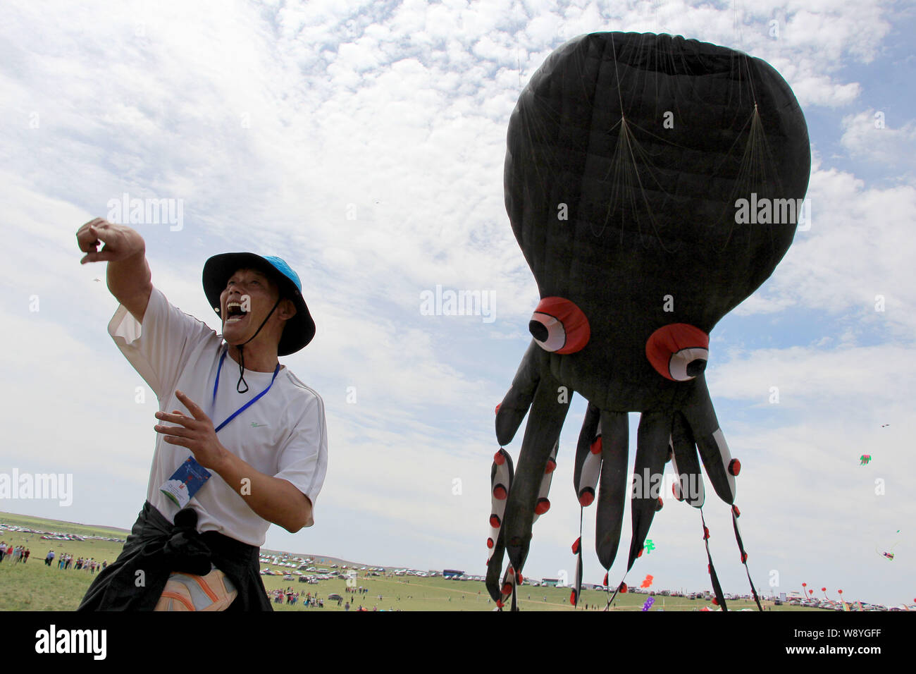 Un uomo cinese dirige i volontari a volare i mondi più grande aquilone nella forma di un polipo su una prateria a Hohhot, porcellane del nord della Mongolia Interna Auton Foto Stock