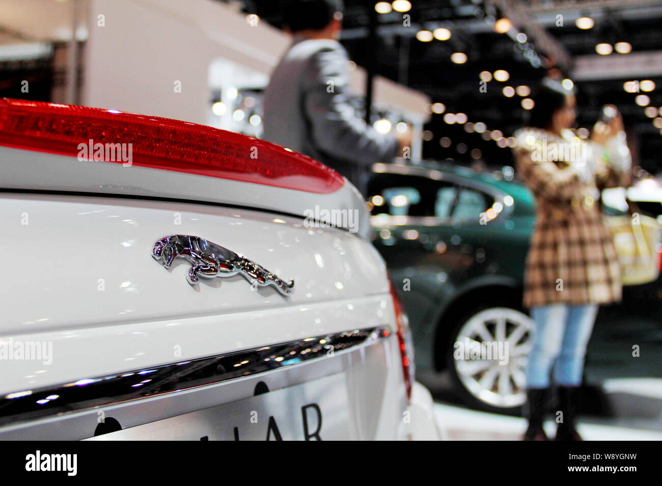 --FILE--i visitatori a piedi passato una Jaguar auto durante una fiera automobilistica a Pechino, in Cina, il 2 novembre 2011. Con la loro punta sul lungo termine devel Foto Stock