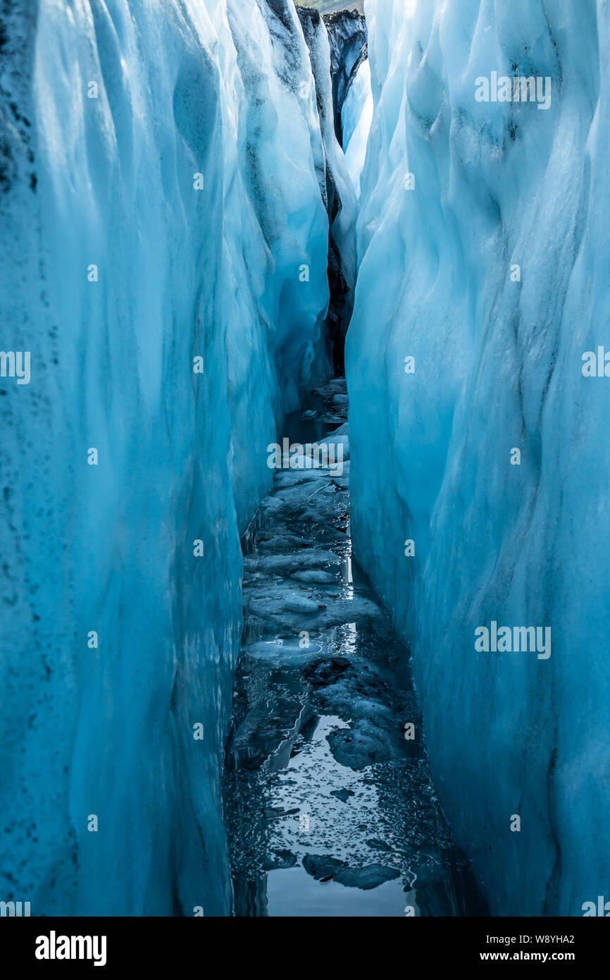 Il ghiaccio del ghiacciaio Matanuska all'interno di un profondo riempiti di acqua crepaccio. La luce blu e il riflesso del cielo nell'acqua sottostante. Foto Stock