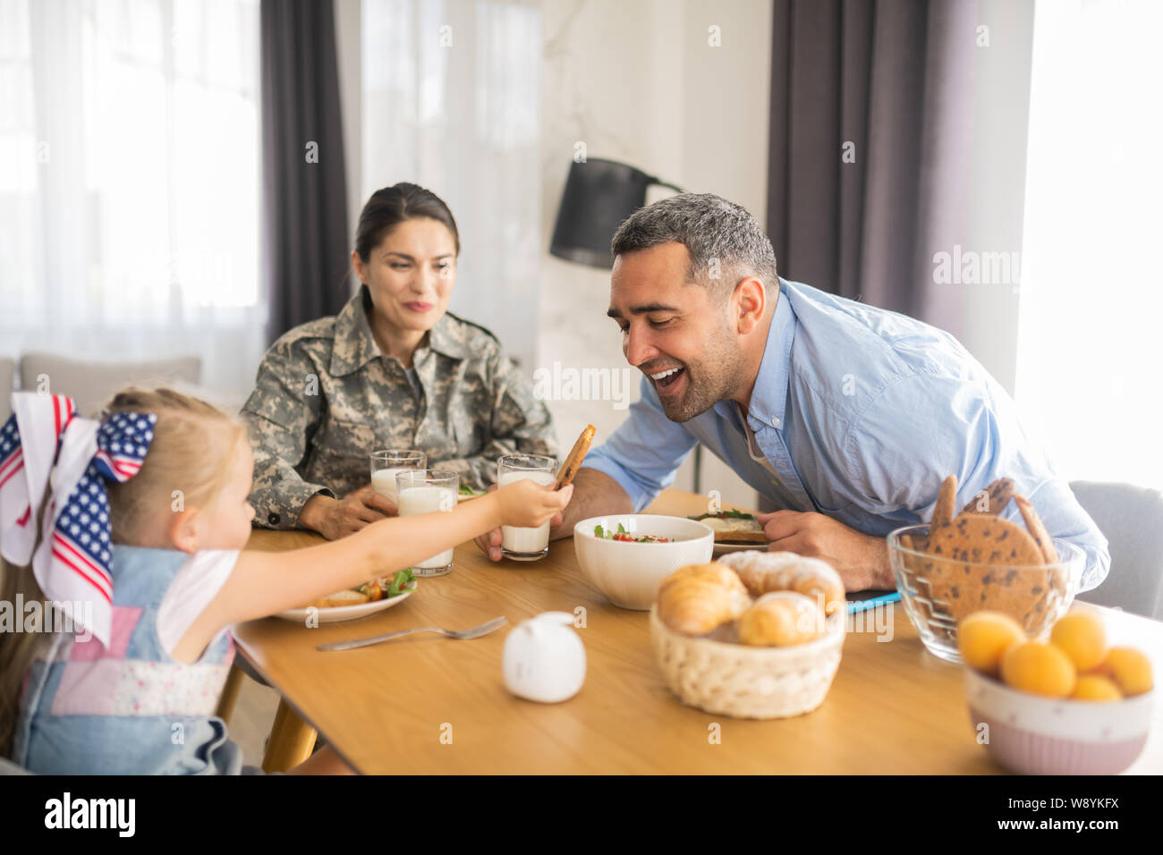 Bella ragazza generosa dando suo cookie a papà Foto Stock