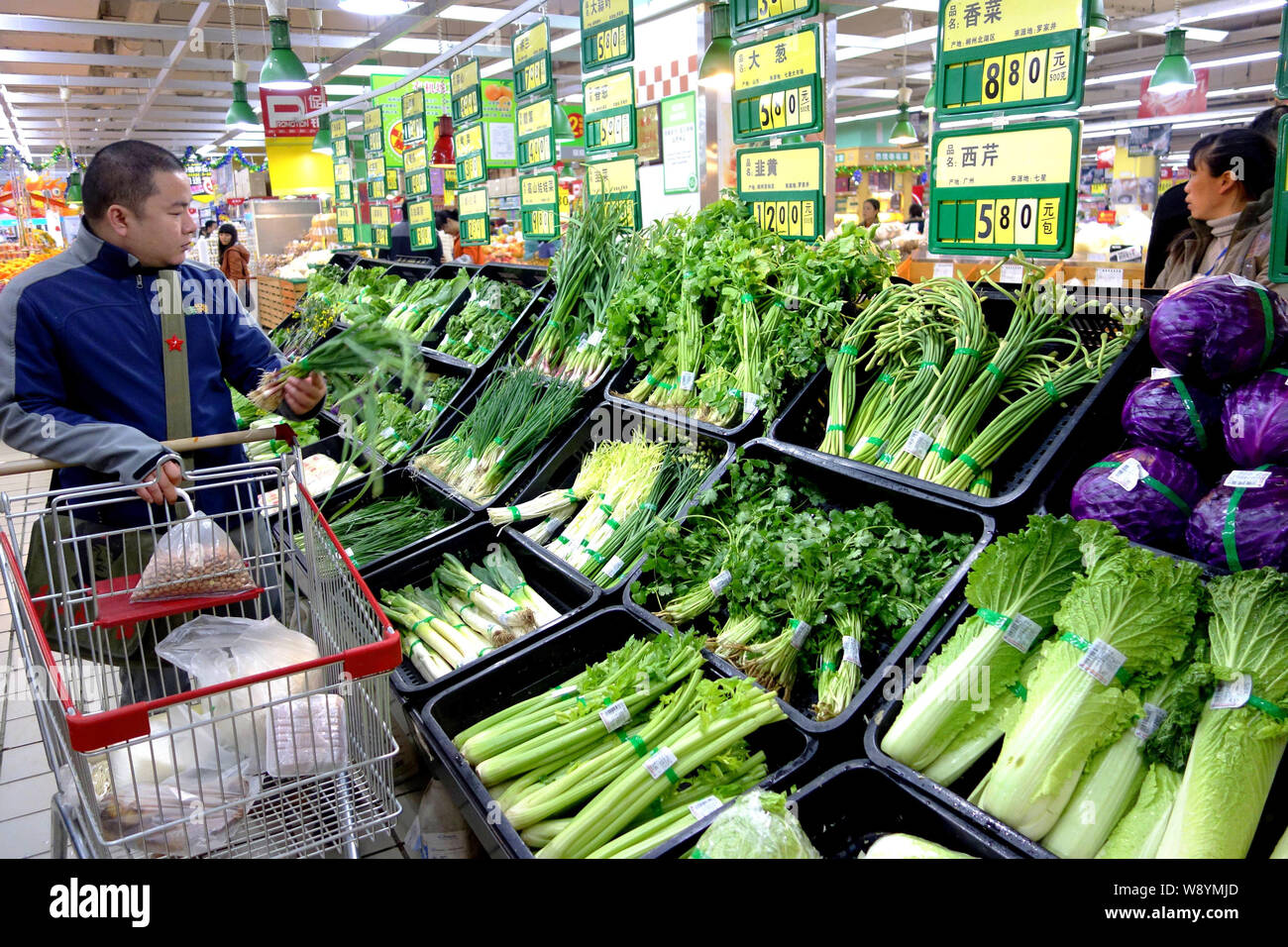 --FILE--clienti negozio per ortaggi in un supermercato in città Chenzhou, porcellane centrale nella provincia del Hunan, 15 dicembre 2013. Porcellane prezzo al consumo inde Foto Stock