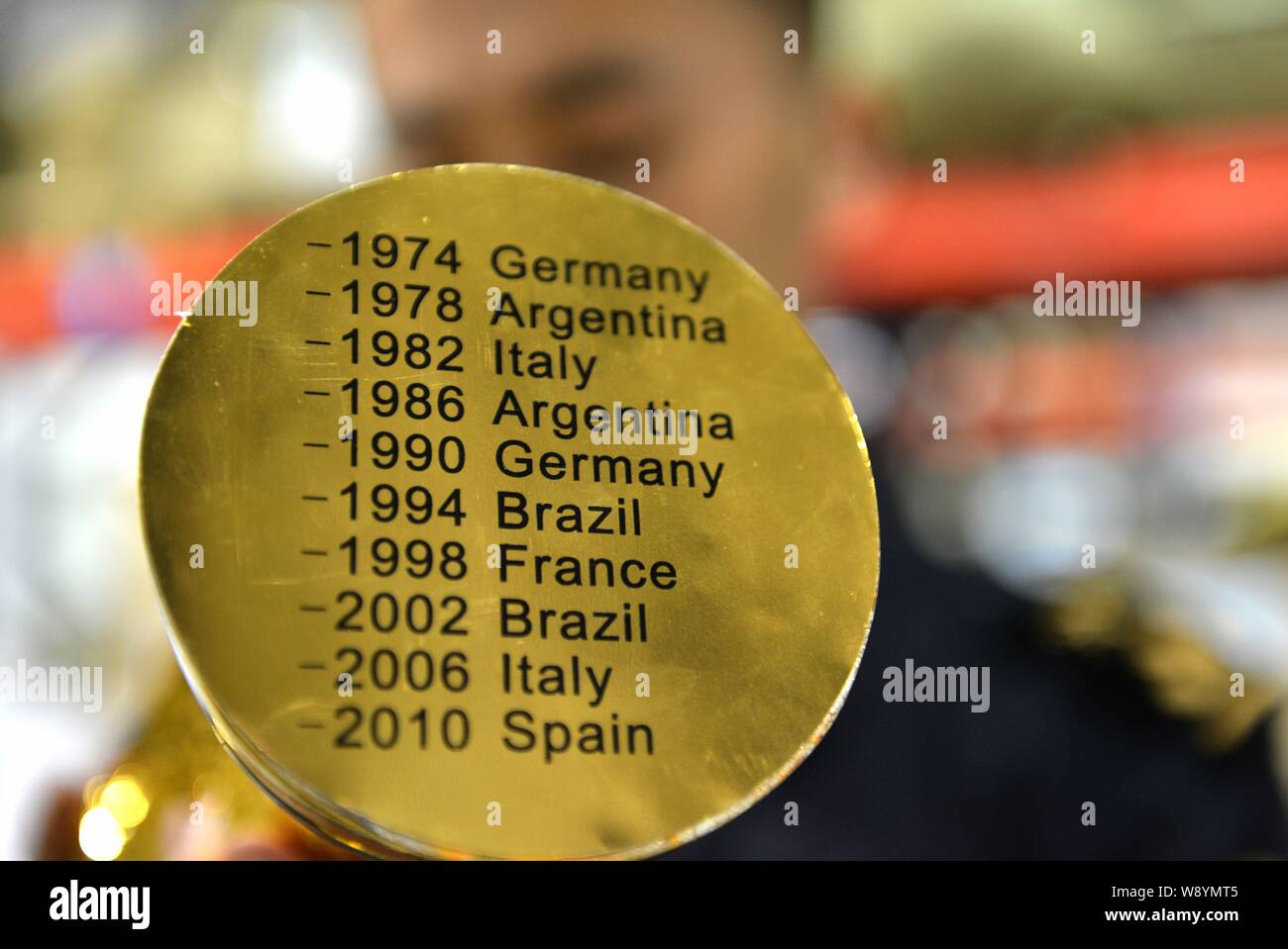 Un Cinese funzionario doganale controlla un grippaggio fake World Cup Trofeo presso un magazzino in Yiwu City East Chinas nella provincia di Zhejiang, 16 aprile 2014. Più di Foto Stock