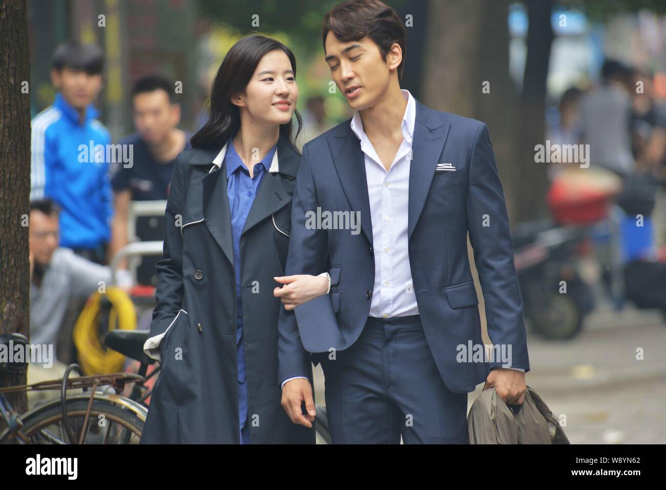 Corea del Sud attore Song Seung-heon, destra e attrice cinese Liu Yifei camminare a braccetto durante una sessione di riprese per il loro filmato nuovo " Terzo Amore" Foto Stock