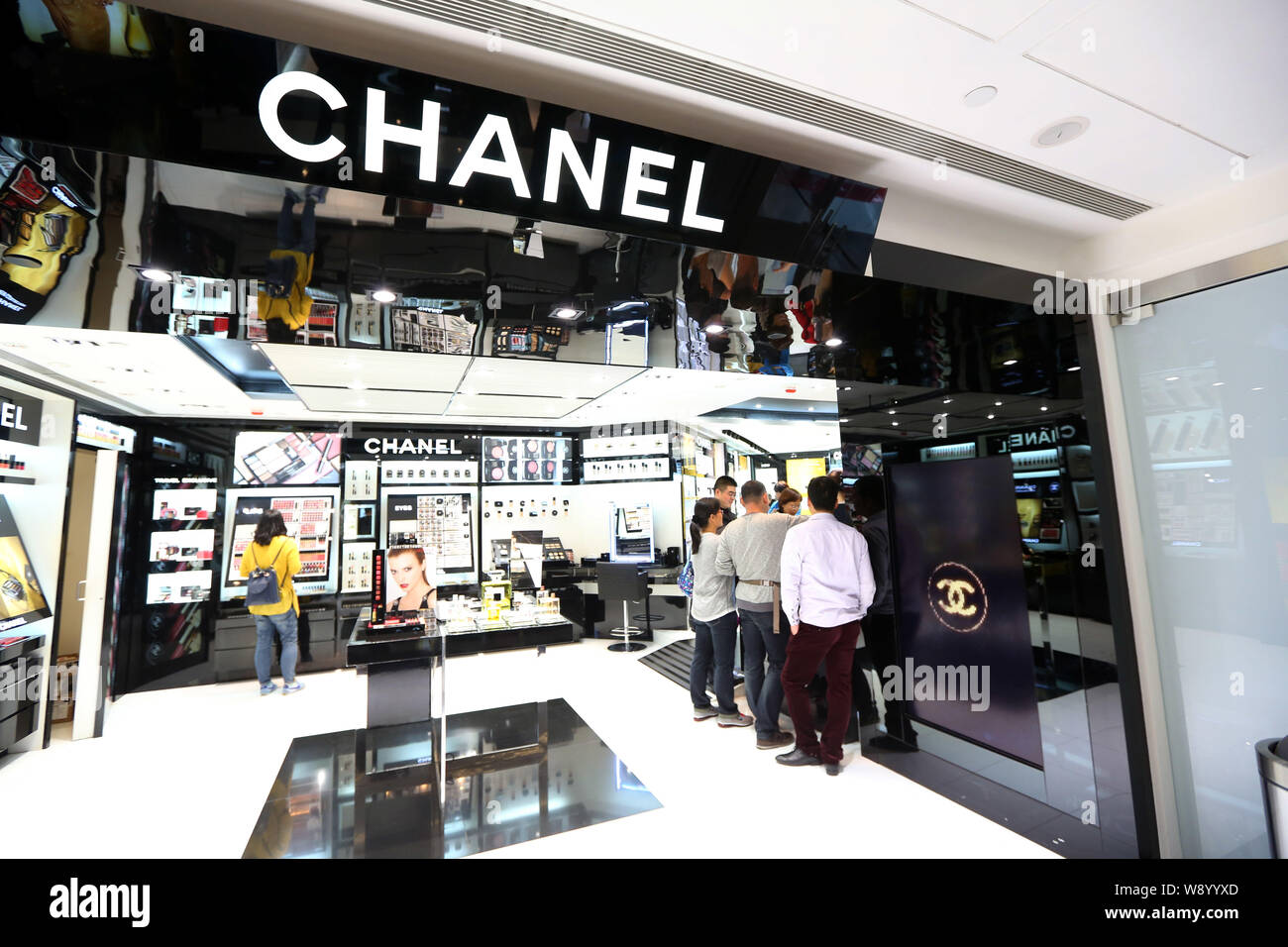 --FILE--i clienti a fare acquisti presso un negozio cosmatics di Chanel a Hong Kong, Cina, 21 dicembre 2013. Beni di lusso, borse, abbigliamento e gioielli sono vedendo thei Foto Stock