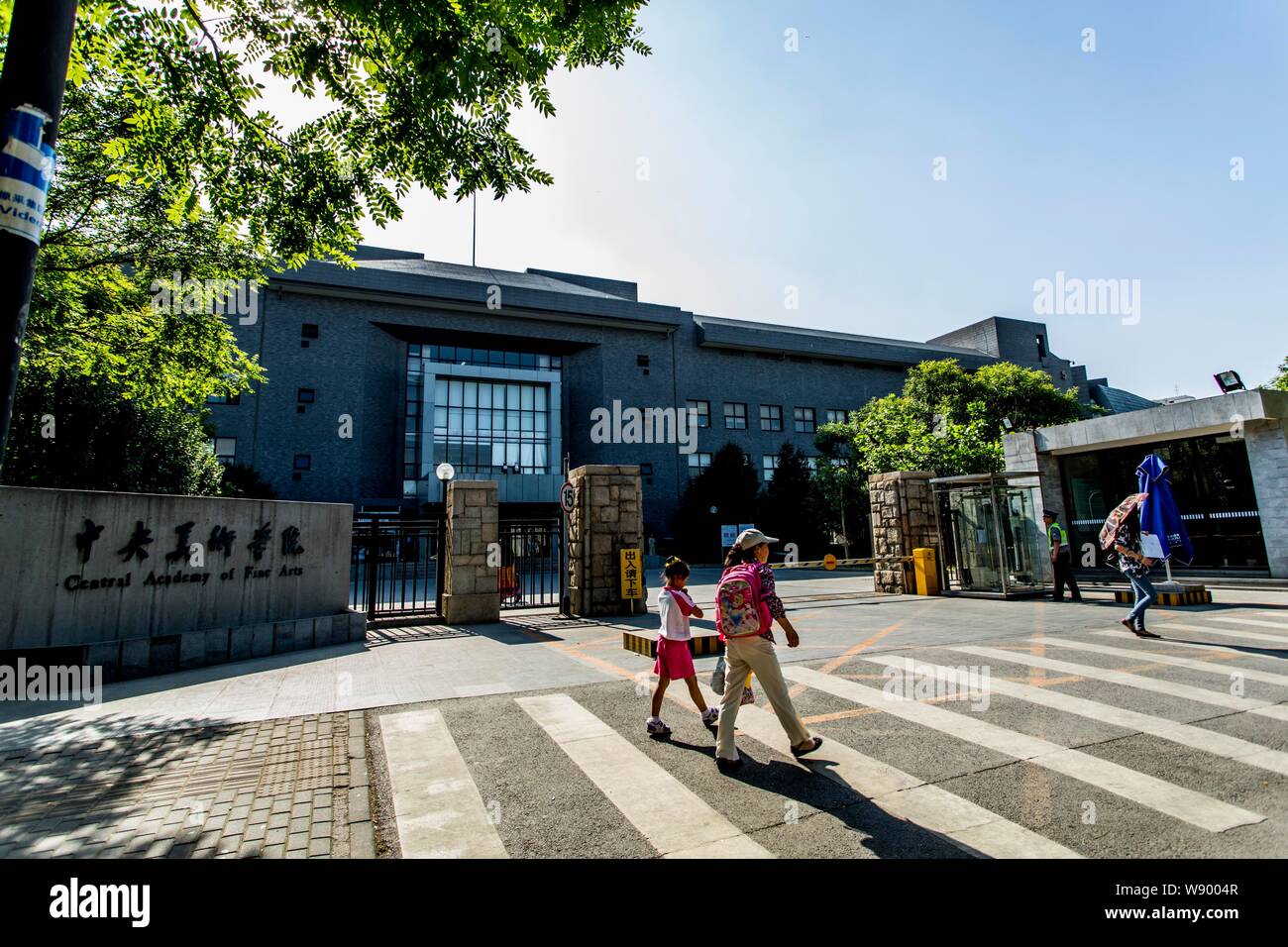 I pedoni a piedi passato il cancello del Centro di Accademia di Belle Arti (CAFA) a Pechino, in Cina, il 30 maggio 2013. Foto Stock
