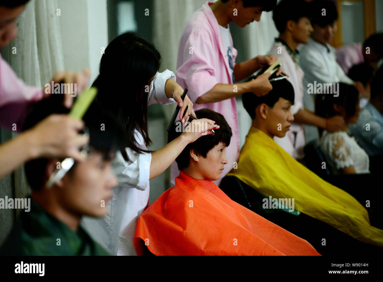 --FILE--studenti cinesi imparare le abilità di parrucchiere a Lanxiang Vocational School di Jinan City East Chinas provincia di Shandong, 24 luglio 2014. Mentre m Foto Stock