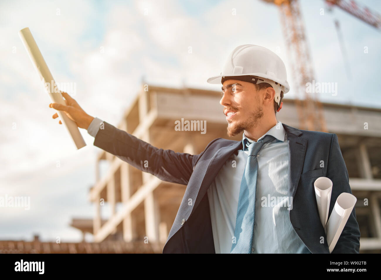 Giovane maschio di ingegnere civile o imprenditore ombra rende sollevando la sua mano nell'aria Foto Stock