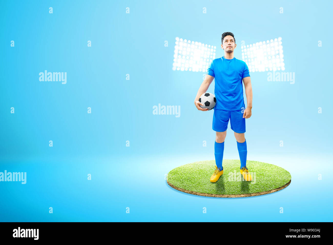Asian football giocatore in possesso della palla sulla sua mano sul campo di calcio con faretti Foto Stock