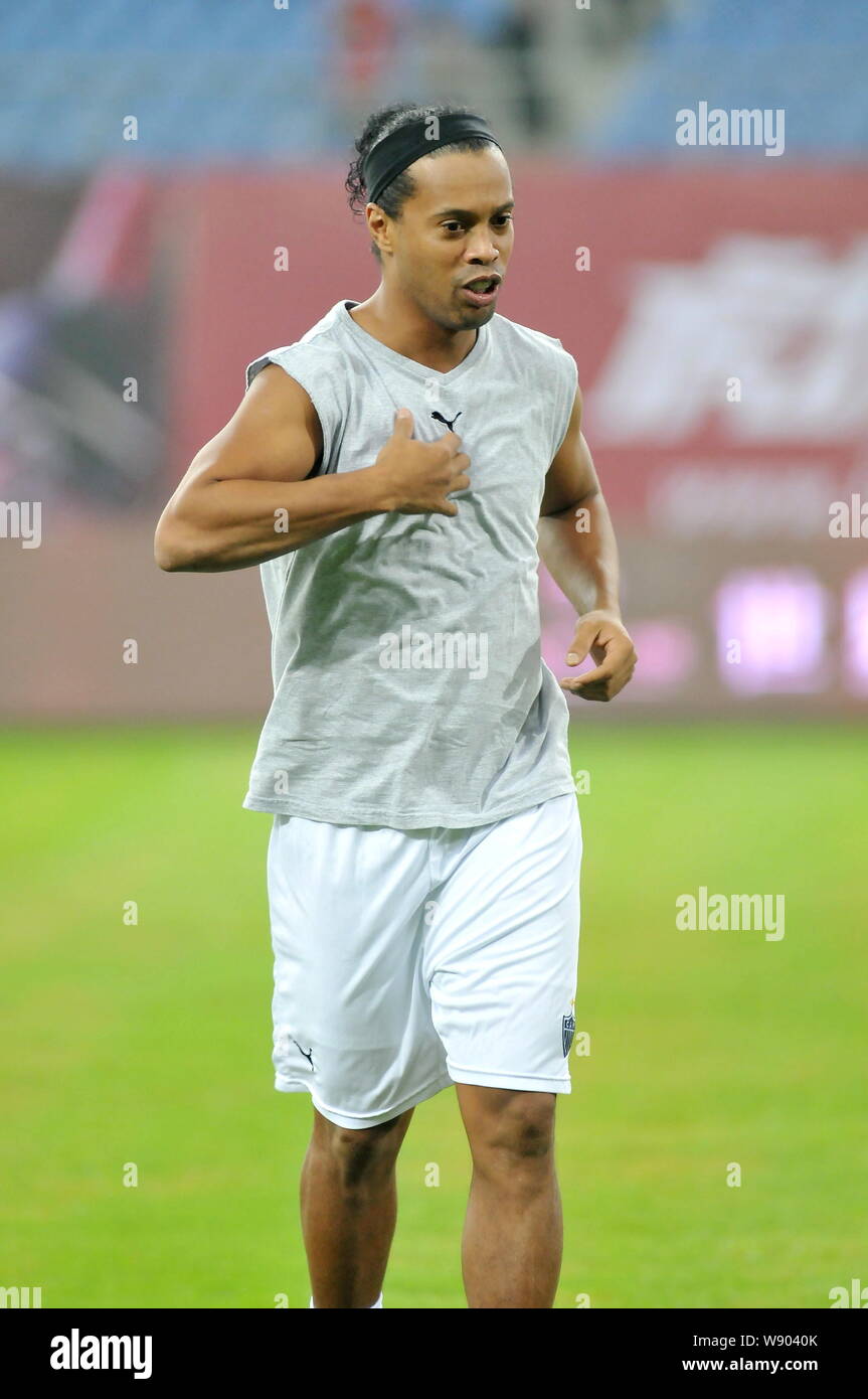 Il calcio brasiliano star Ronaldinho di Atletico Mineiro si riscalda prima di un amichevole partita di calcio contro Chinas Jiangsu Sainty nella città di Nantong, EST C Foto Stock