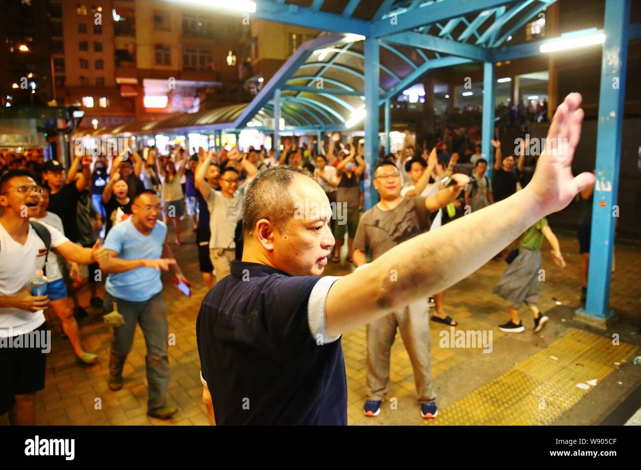 Hong Kong, Cina. 11 Ago, 2019. Le manifestazioni si è trasformato in violenza, con la polizia sparando gas lacrimogeni a manifestanti attraverso Hong Kong come chiamata di manifestanti per la democrazia. Qui i residenti cercano di sottrarsi alle zone di tumulto al Mei Foo station wagon. Credito: Gonzales foto/Alamy Live News Foto Stock