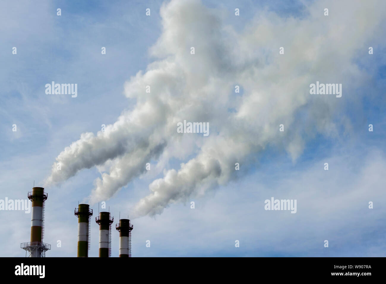 Tubi industriali rilasciare grigio fumo sporca nel cielo, aria e inquinamento ambientale, problemi ambientali. Le emissioni tossiche Foto Stock