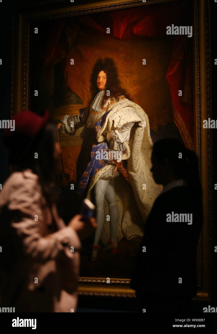 Un visitatore cinese guarda la pittura, Luigi XIV, dall artista francese Hyacinthe Rigaud Il duomo, durante una mostra in occasione del cinquantesimo anniversario della establ Foto Stock