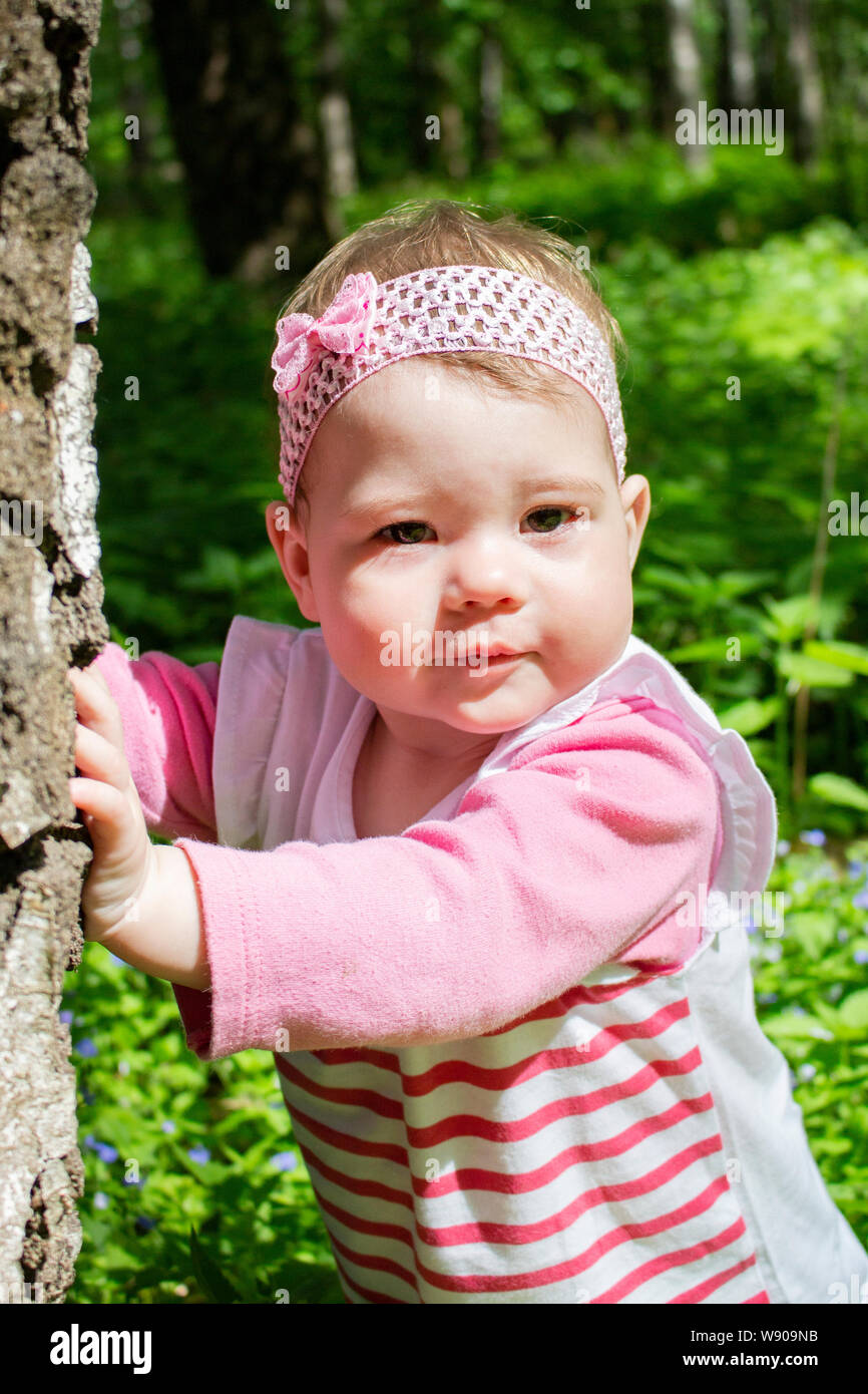 Ritratto di una bambina passeggiate nel parco. La luce diretta del sole, la  faccia del bambino di close-up, abiti rosa. Bambina con un ritratto di  prua. unione Foto stock - Alamy