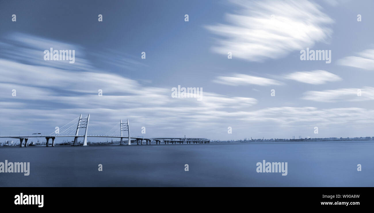 Dai toni monocromatici paesaggio con nuvole, ponte sul mare e la strada sopraelevata Foto Stock