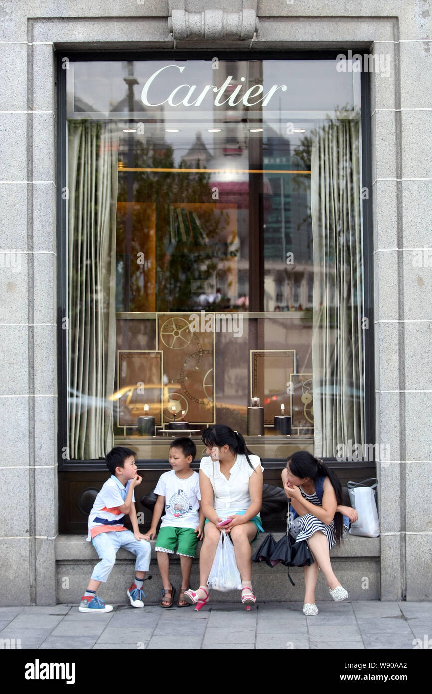 I turisti il resto di fronte alla boutique di moda di Cartier al Bund 18 in Cina a Shanghai, 7 agosto 2014. Lungo il Bund e la famosa area del litorale o Foto Stock