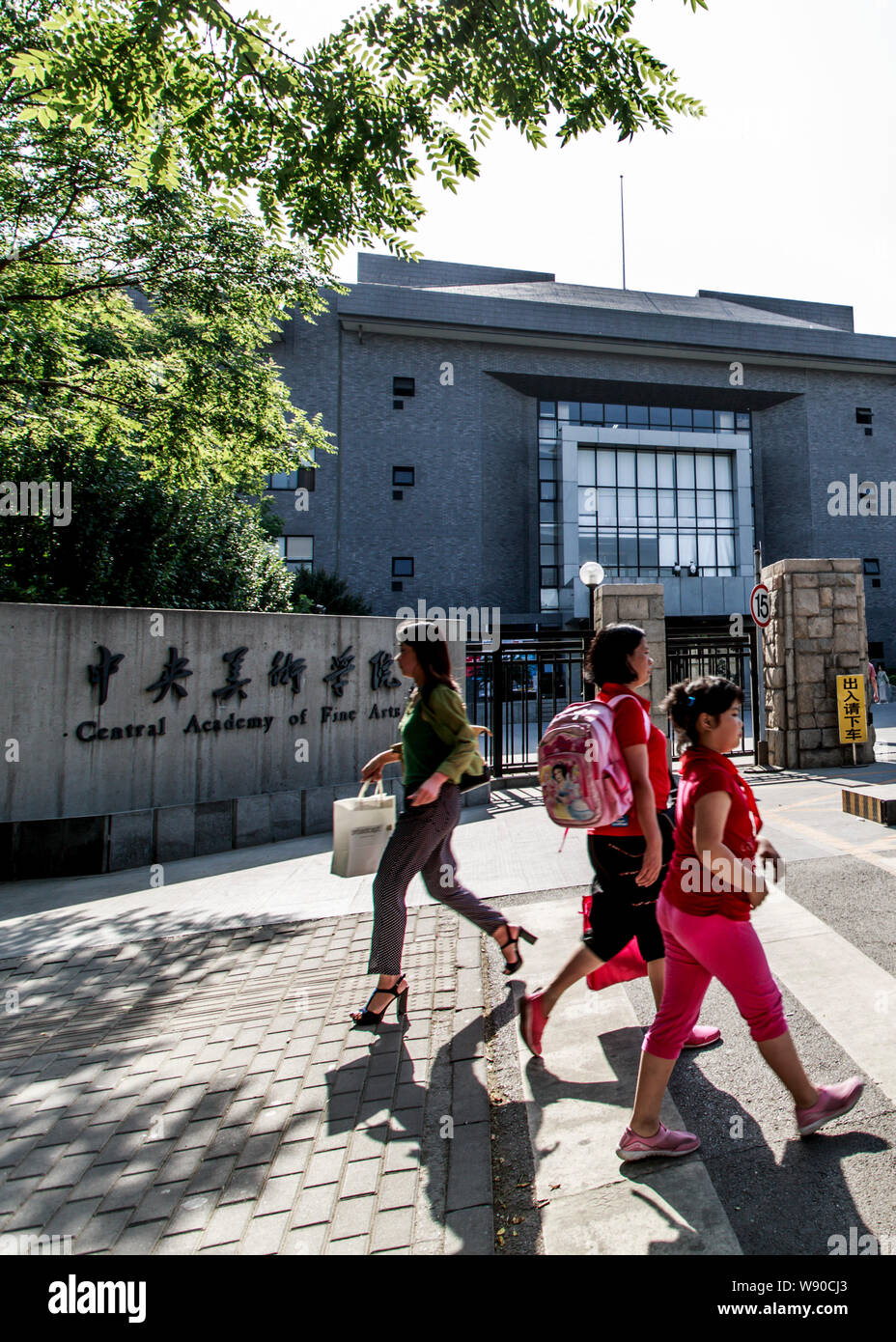 I pedoni a piedi passato il cancello del Centro di Accademia di Belle Arti (CAFA) a Pechino, in Cina, il 30 maggio 2013. Foto Stock