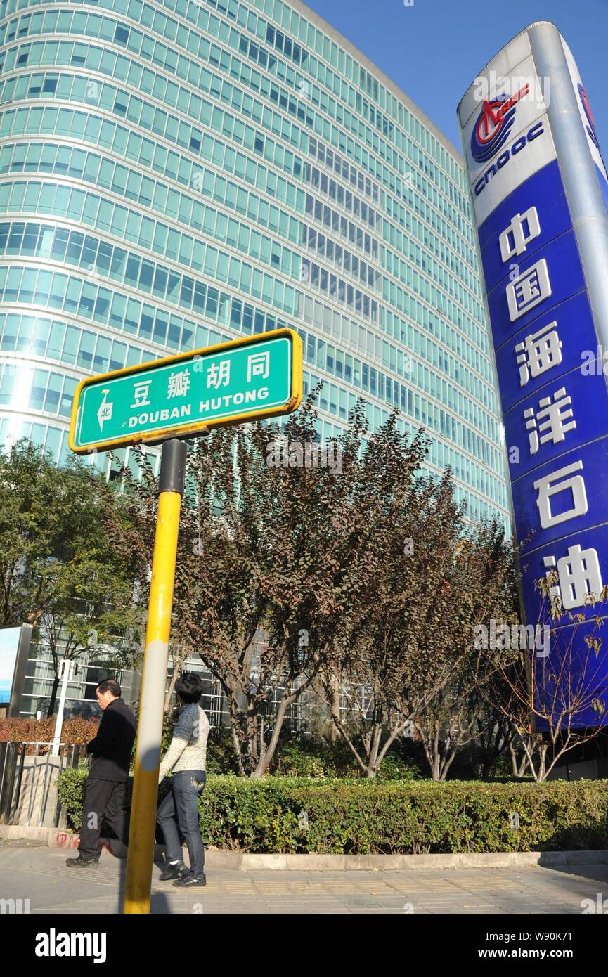 --FILE--pedoni a piedi passato il quartier generale di CNOOC (China National Offshore Oil Corporation) a Pechino in Cina, 13 novembre 2011. Mento Foto Stock