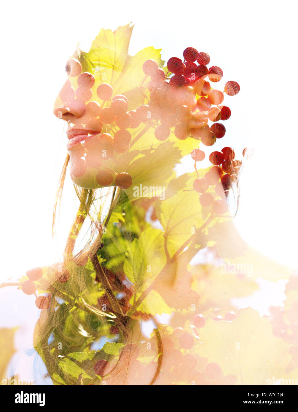 La doppia esposizione ritratto di colore verde brillante foglie e frutti rossi combinato con un pacifico volto di donna Foto Stock