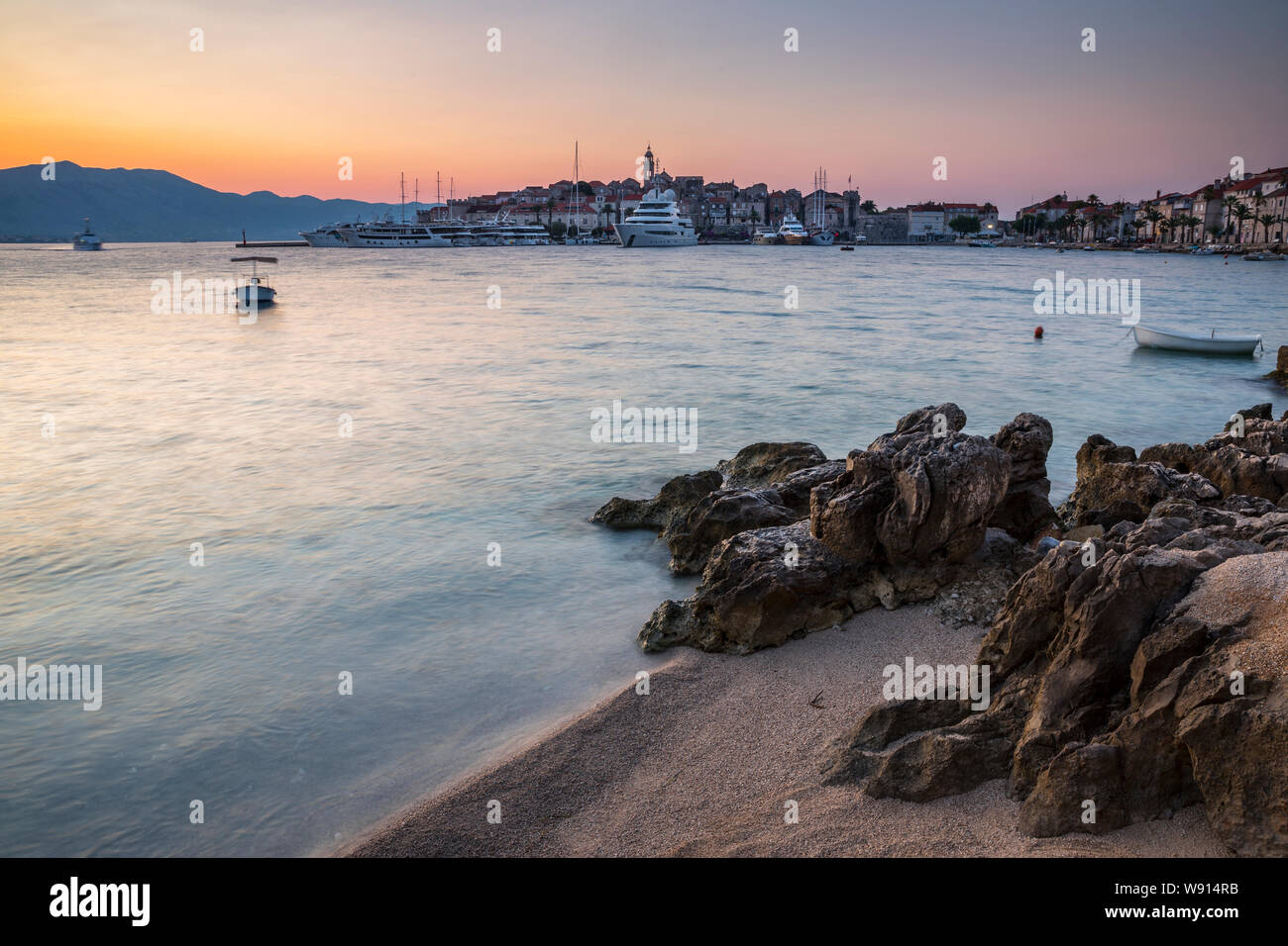 Spiaggia rocciosa di fronte la città di Korcula di sunrise Foto Stock