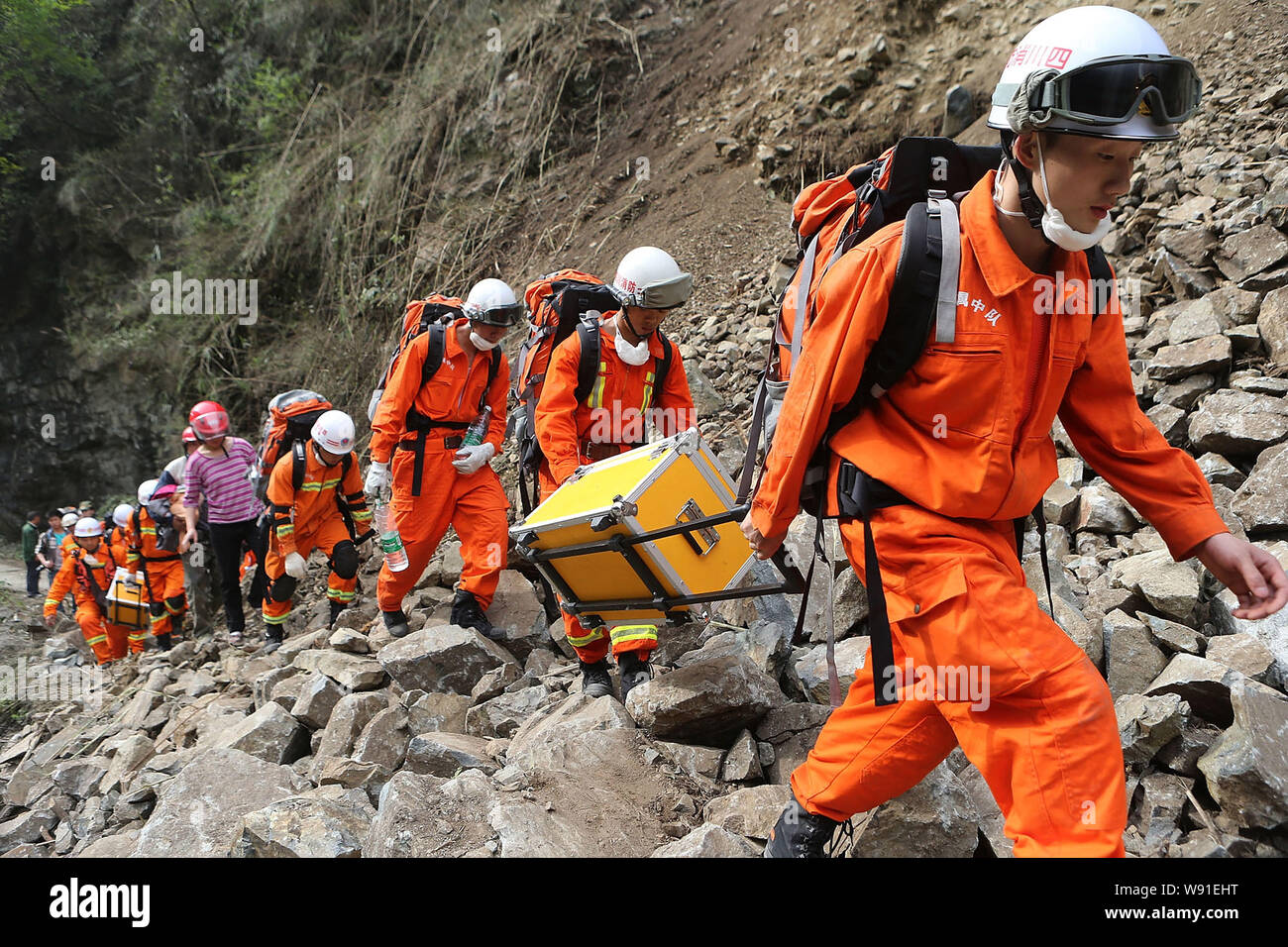 I vigili del fuoco portano soccorso materiale attraverso una frana sulla strada per il terremoto sito di Baoxing county, YaAn city, southwest Chinas nella provincia di Sichuan, 2 Foto Stock