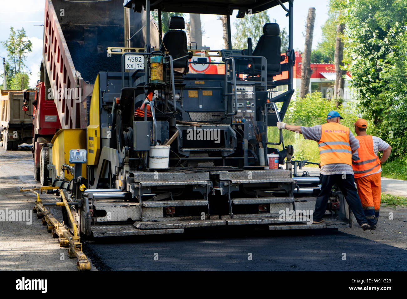 La regione di Celjabinsk, Russia - Agosto 2019. Nuovo lastricatore in azione. Riparazione su strada. Asfalto da pavimentazione. La posa di un nuovo strato di asfalto Foto Stock