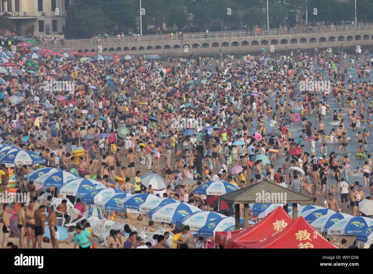 I villeggianti overcrowd Qingdao No.1 spiaggia balneare su una torrida giornata nella città di Qingdao, est Chinas provincia di Shandong, 3 agosto 2013. Cittadino locale Foto Stock