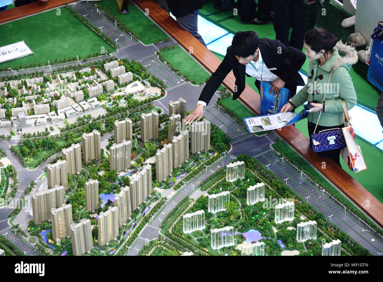 --FILE--cinese i homebuyers visualizza i modelli di alloggiamento durante una fiera immobiliare a Pechino in Cina, 11 aprile 2013. Controllare home aumenti di prezzo in Cina Foto Stock