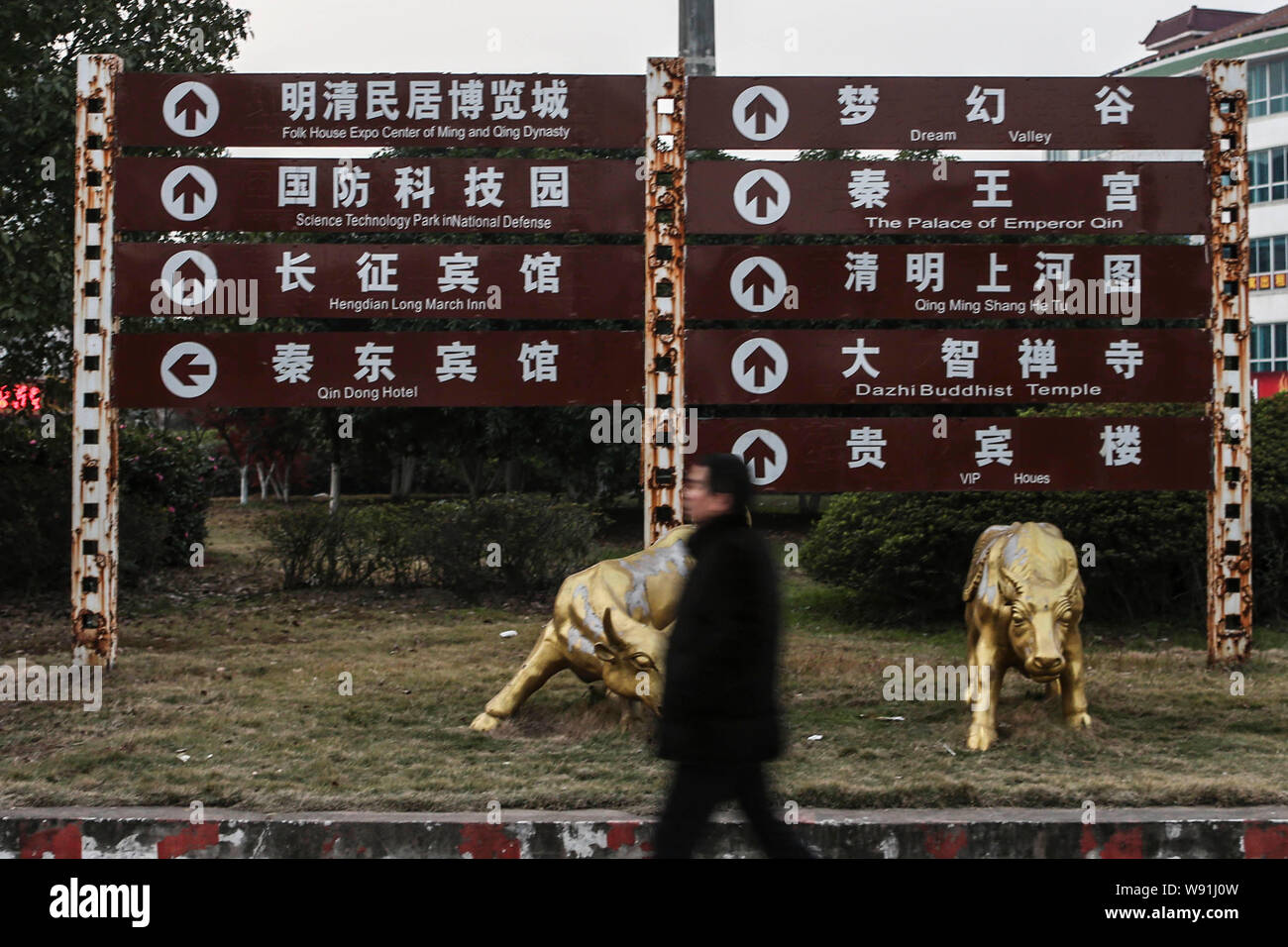 --FILE--un pedone passato passeggiate cartelli segnaletici stradali a Hengdian World Studios di Dongyang city east Chinas nella provincia di Zhejiang, 9 dicembre 2012. Essendo il wor Foto Stock