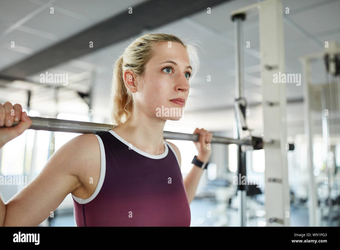 Giovane donna treni i muscoli delle gambe in barbell stazione nel centro fitness Foto Stock