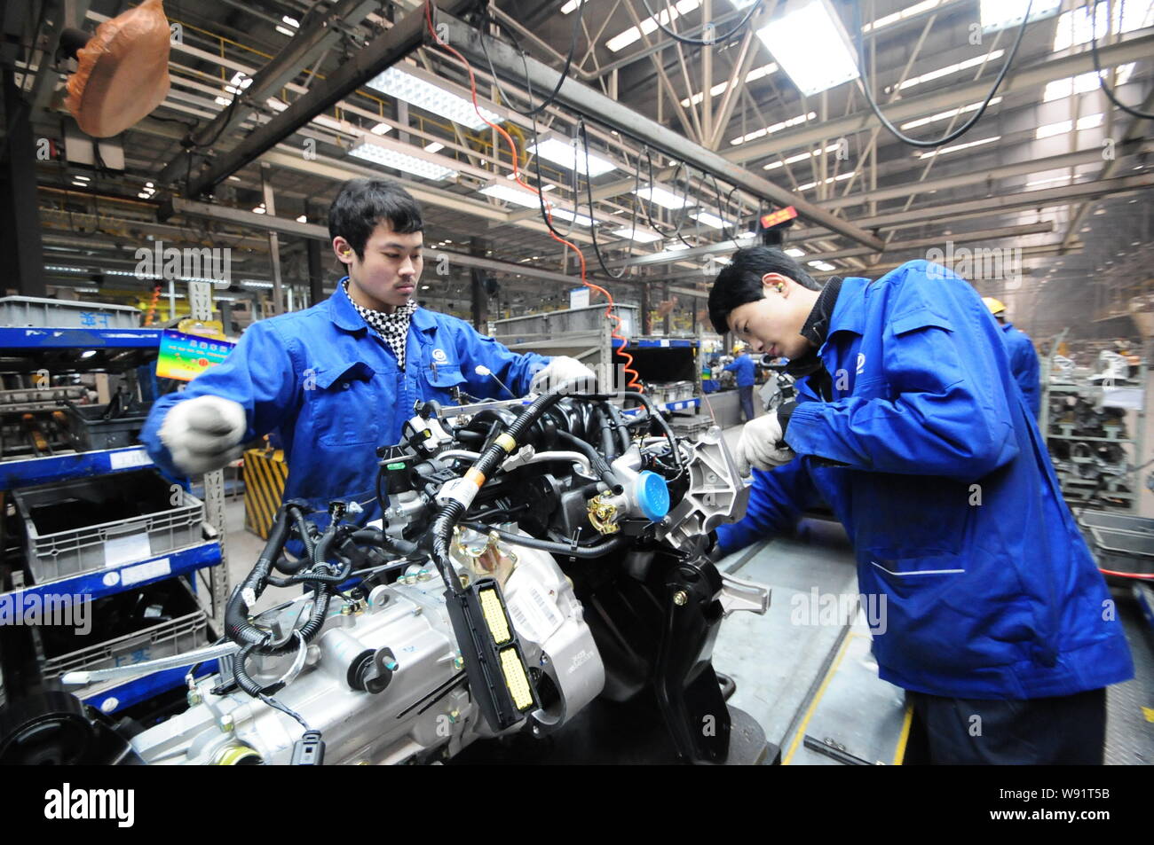 Cinese operai di assemblare un motore a fase I di piano del motore di SAIC-GM-Wuling Automobile Co., Ltd. in Qingdao City East Chinas Shandong pr Foto Stock