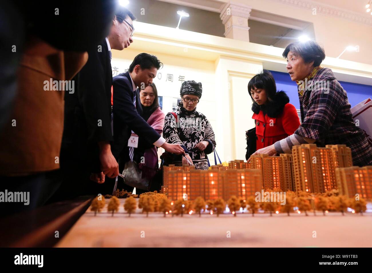 --FILE--cinese i homebuyers visualizza i modelli di alloggiamento durante una fiera immobiliare in Cina a Shanghai, 15 marzo 2013. Controllare home aumenti di prezzo in mento Foto Stock