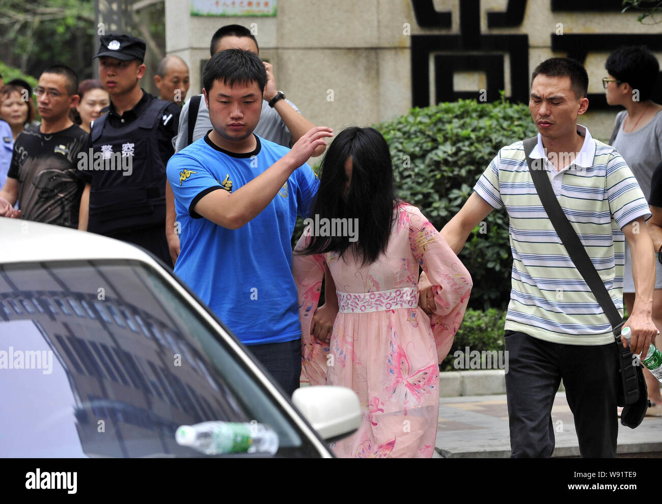 La donna, anteriore, un sospetto che ha sparato in un edificio residenziale, è arrestato dalla plainclothes locali ufficiali della polizia di Chengdu, southwest Chinas Foto Stock