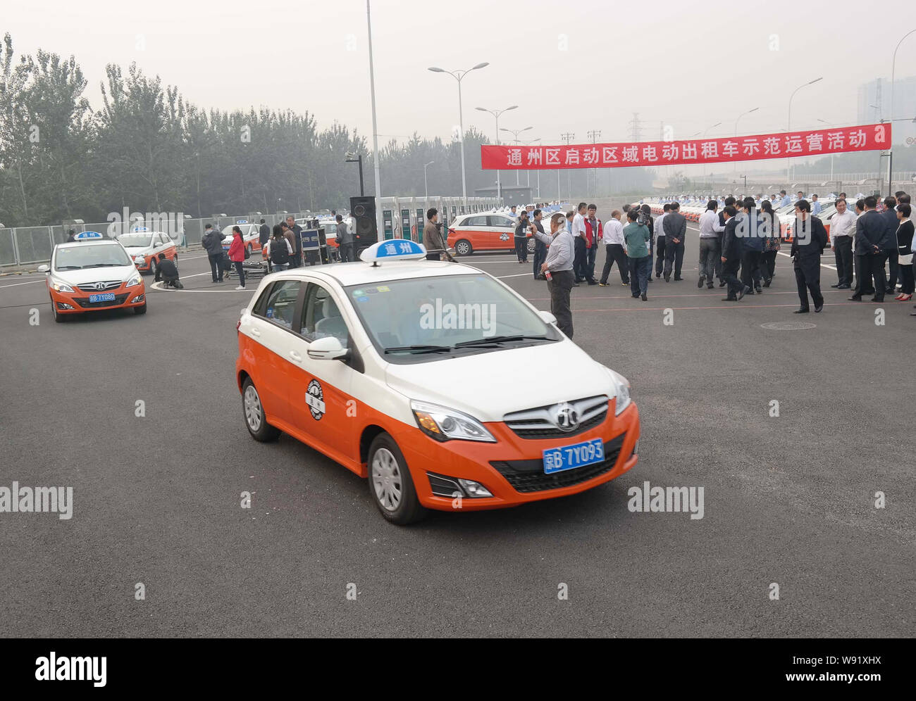 Il cinese dei tassisti di guidare il loro taxi elettrico fuori di una stazione di carica nel Distretto di Tongzhou, Pechino, Cina, 29 settembre 2013. Pechino è aspettarsi Foto Stock