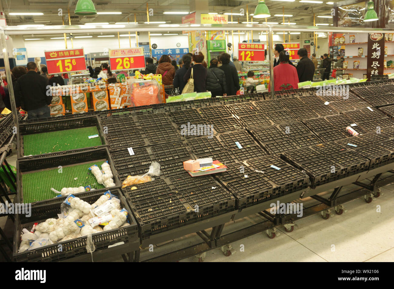 I clienti cinesi a piedi passato quasi gli scaffali vuoti al supermercato Walmart programmati per chiudere in Luoyang city, porcellane centrale provincia di Henan, 5 Decem Foto Stock