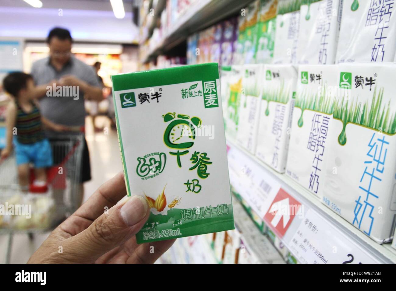 --FILE--un cinese cliente acquista un cartone di latte Mengniu in un supermercato in Xuchang, porcellane centrale provincia di Henan, 22 giugno 2013. Il Inner-Mongol Foto Stock