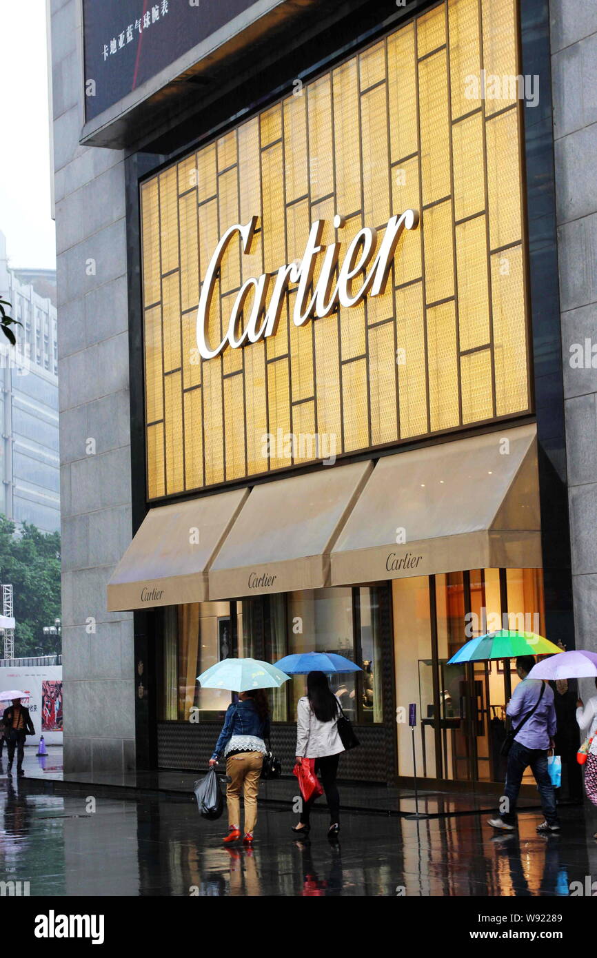 I pedoni a piedi passato una boutique di Cartier a Chongqing Cina, 5 settembre 2013. Lusso attira sempre molta attenzione ma si potrebbe non sapere come molto Foto Stock